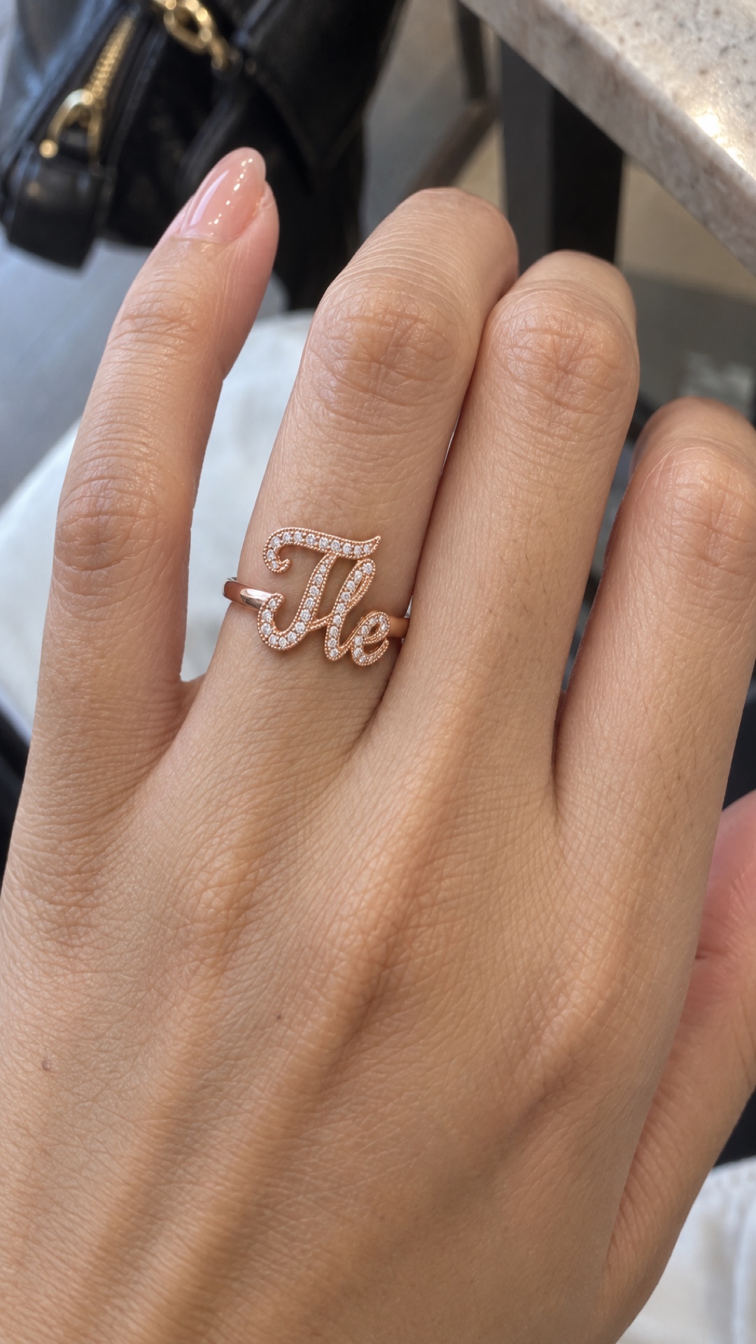 ภาพแหวนชื่อ Tle ขณะสวมบนมือ